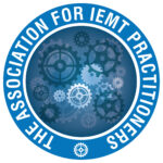 NLP A blue circular logo with interlocking gears in the center, symbolizing NLP Hypnotherapy and healing, surrounded by the words THE ASSOCIATION FOR IEMT PRACTITIONERS in white capital letters along the border. Hypnotherapy