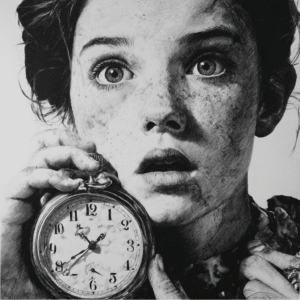 NLP A young person with wide eyes and freckles holds a large pocket watch, looking surprised or alarmed. The black-and-white image, rich in dramatic shadows, evokes the intensity of an NLP hypnotherapy healing or recovery moment. Hypnotherapy